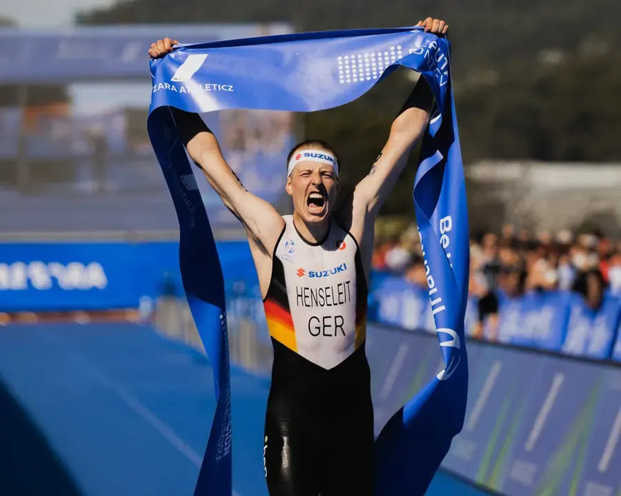 Triathlet im Zieleinlauf mit Zielband über dem Kopf